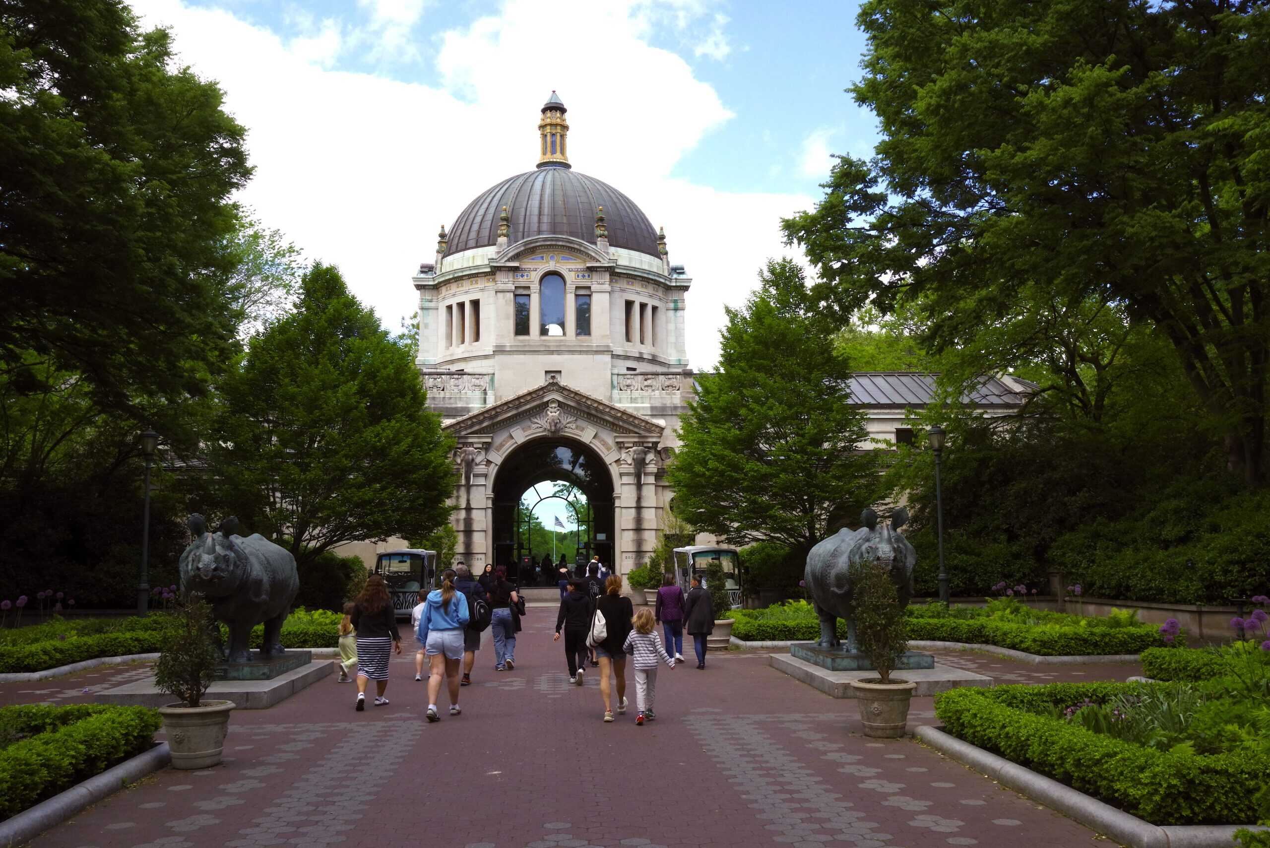 Visitors approaching the domed Zoo Center building at the Bronx Zoo
