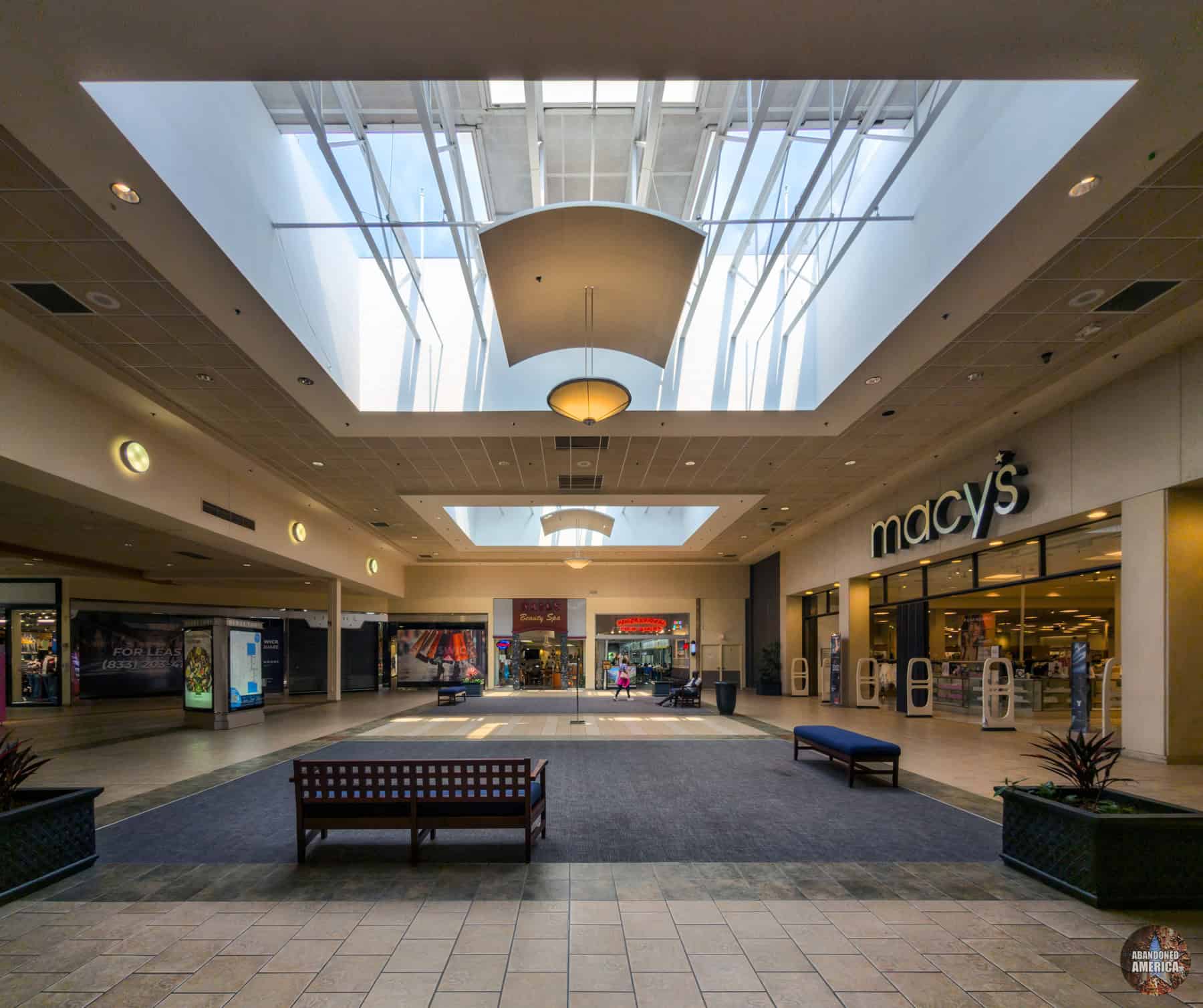 Skylights punctuated by the curved panels and light fixtures common in post-2000s mall updates decorate anchor entrances